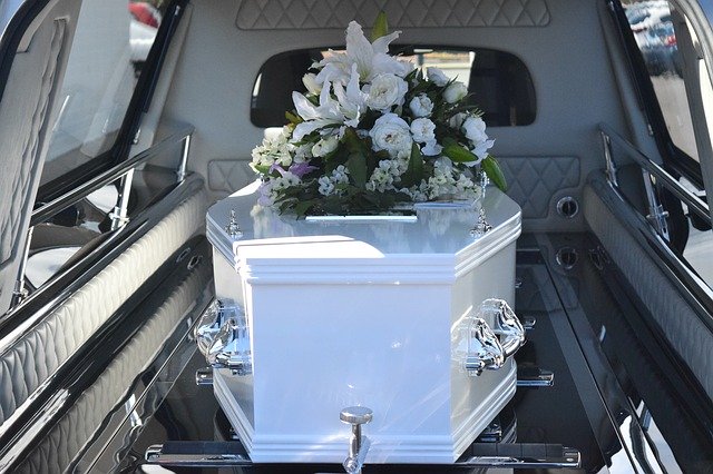 Ein weißer Sarg in einem Leichenwagen auf dem Weg zur Beerdigung.