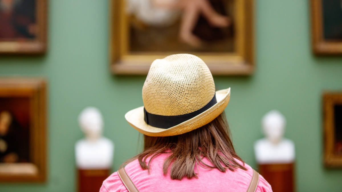 Eine Frau betrachtet Bilder im Museum.