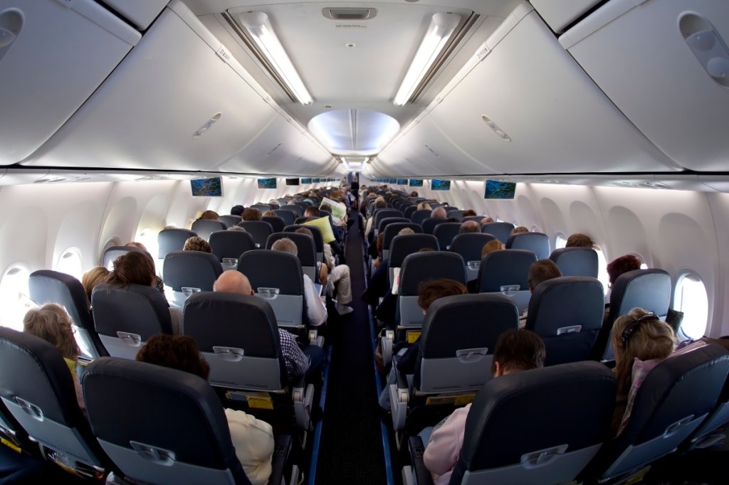 Passagiere sitzen in einem Flugzeug auf ihren Plätzen.