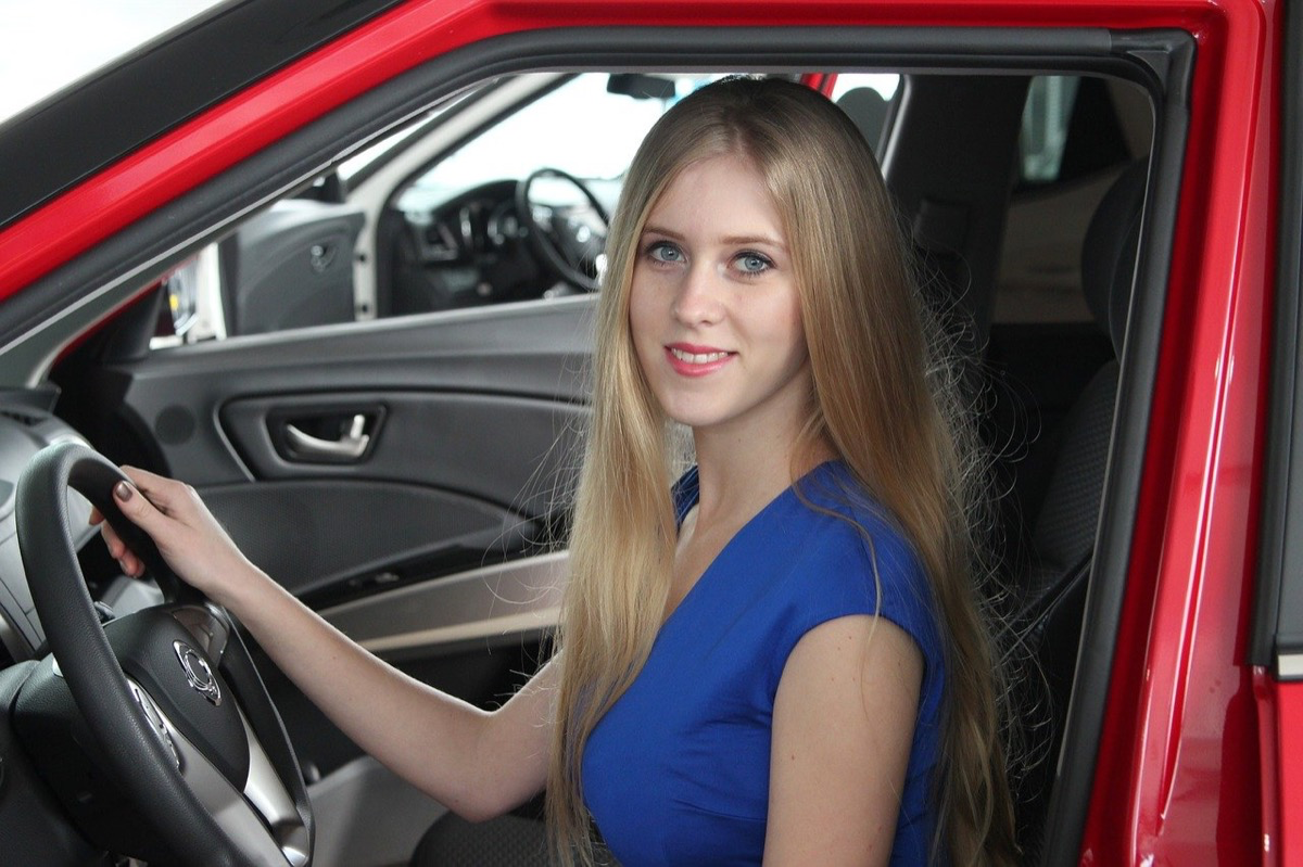 Eine blonde junge Frau sitzt in einem Auto