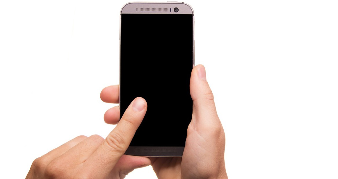 Eine Hand waehlt Nummern auf dem Display eines Smartphones