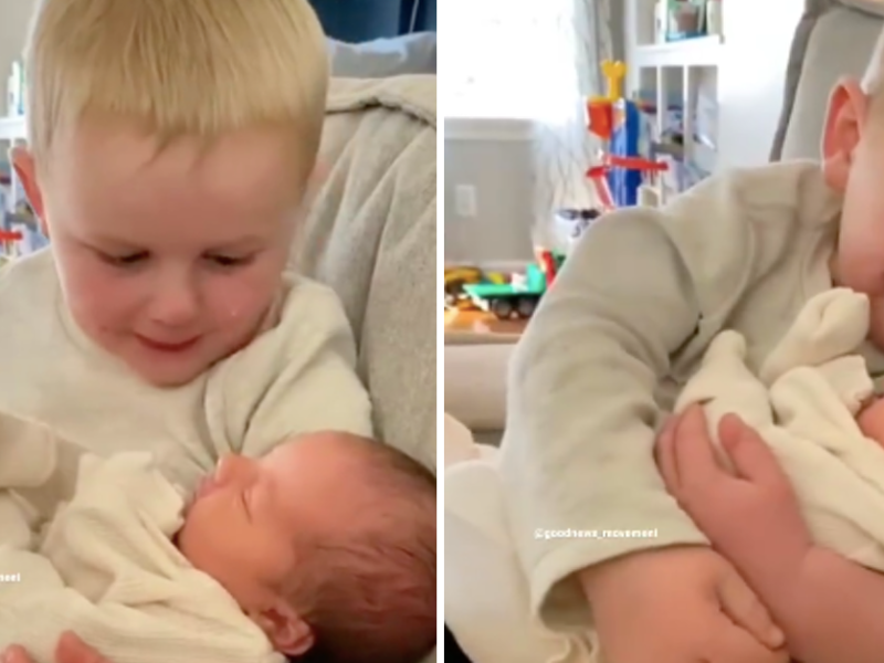 Kleiner Bruder schaut liebevoll auf neugeborene Baby-Schwester