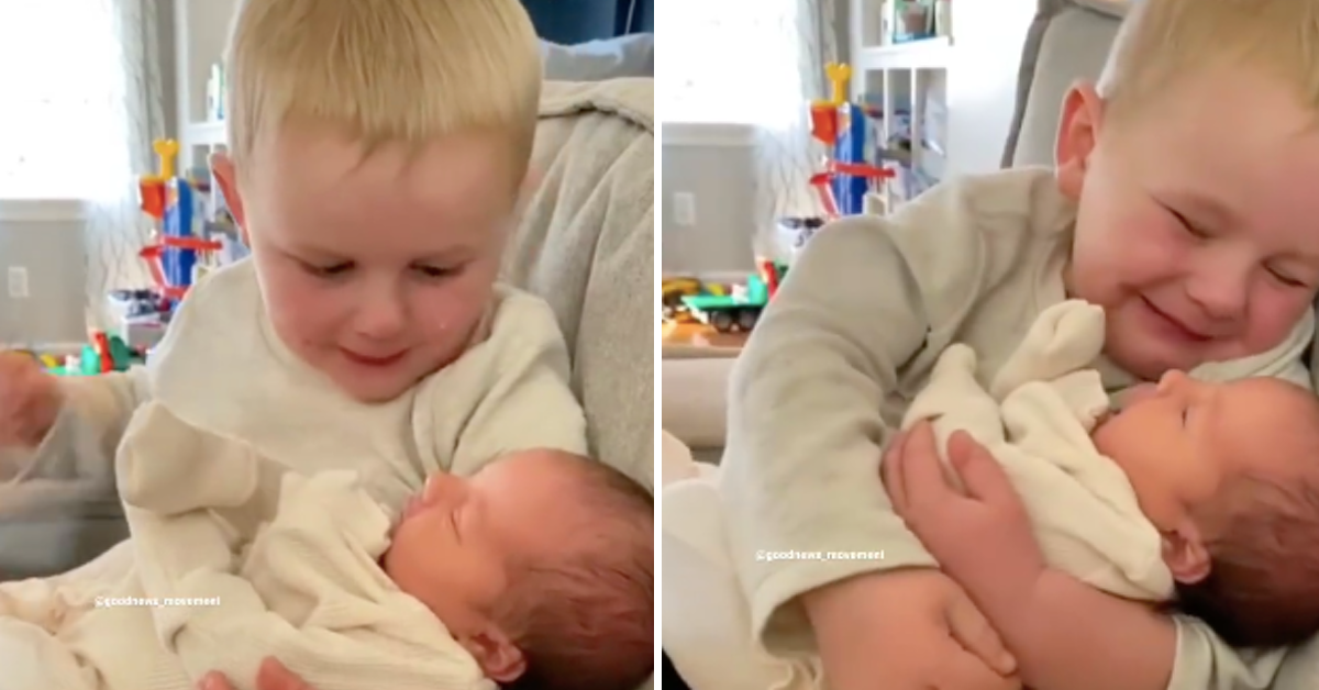 Kleiner Bruder schaut liebevoll auf neugeborene Baby-Schwester