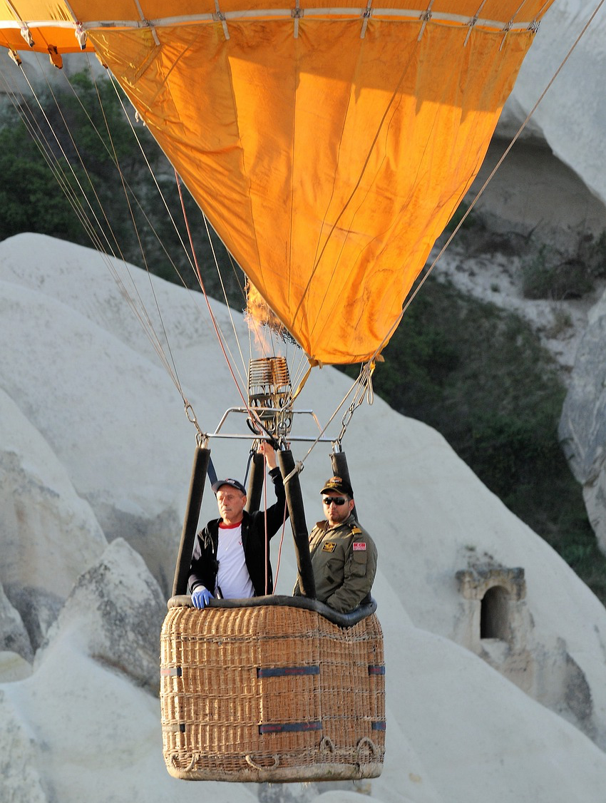 Ein Heißluftballon mit zwei Männern vor einem Berg