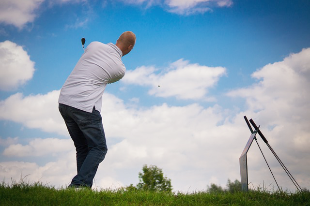 Ein Mann spielt Golf und wird beim Abschlag fotografiert
