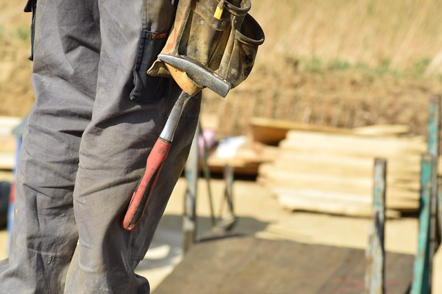 Ein Bauarbeiter mit Werkzeuggürtel und Hammer auf einer Baustelle