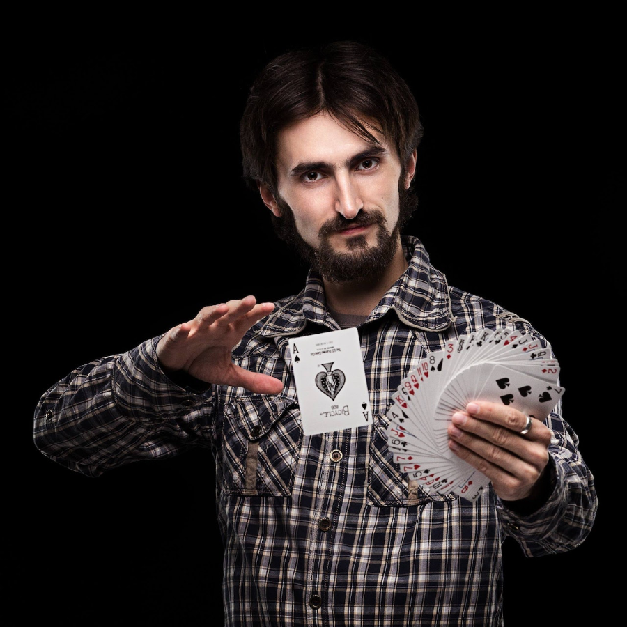 Ein Zauberer zeigt einen Kartentrick und lässt eine Karte schweben
