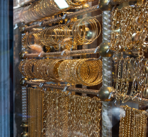 Goldene Ketten, Halsketten und Schmuck hängen im Schaufenster eines Juweliergeschäfts.