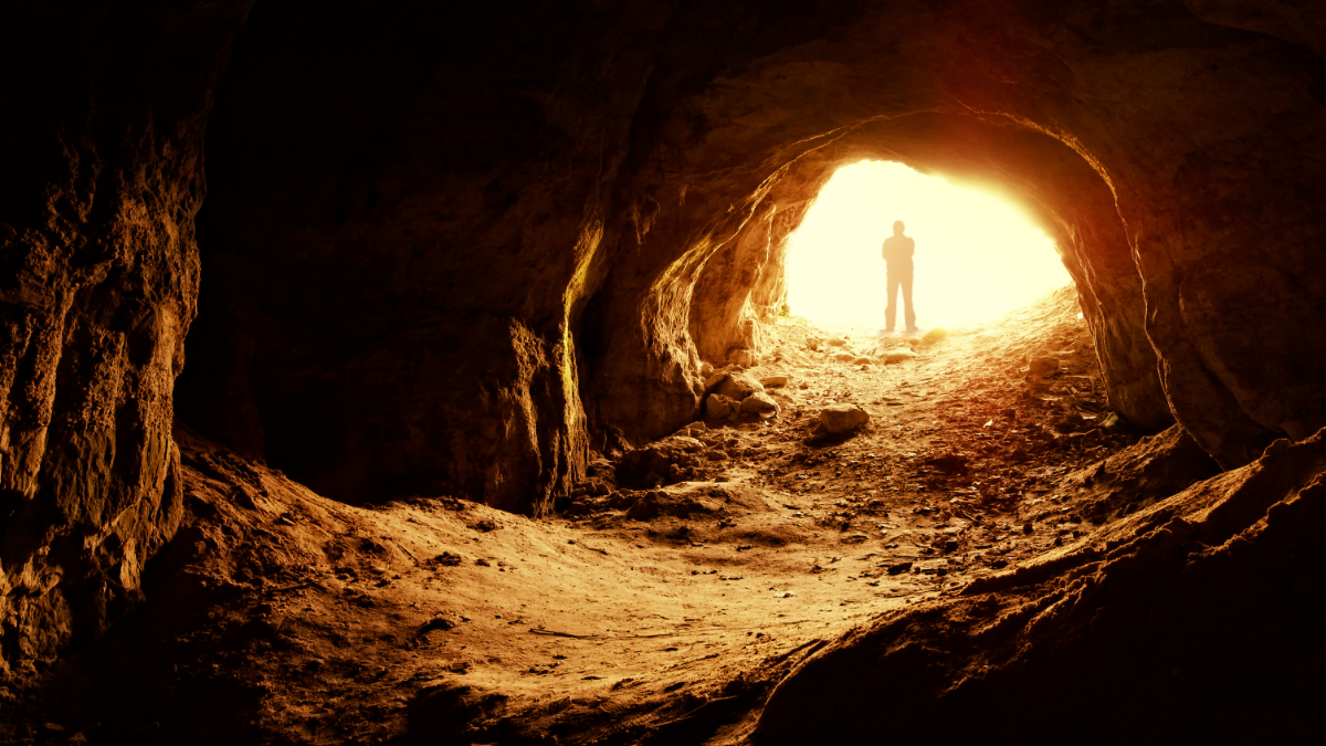 Ein Mann steht an einem Höhleneingang.