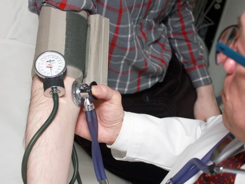 Ein Arzt misst den Blutdruck eines Patienten.