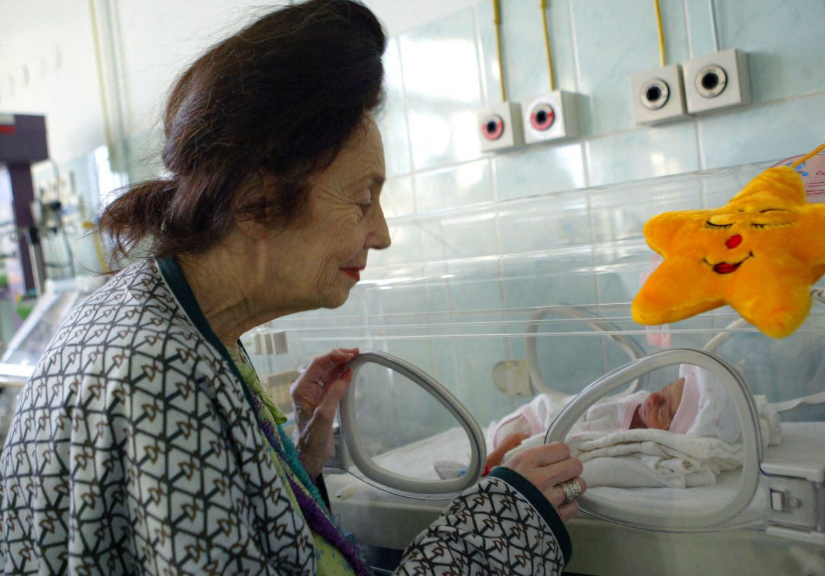Eine Frau betrachtet ein Baby in einem Krankenhaus.