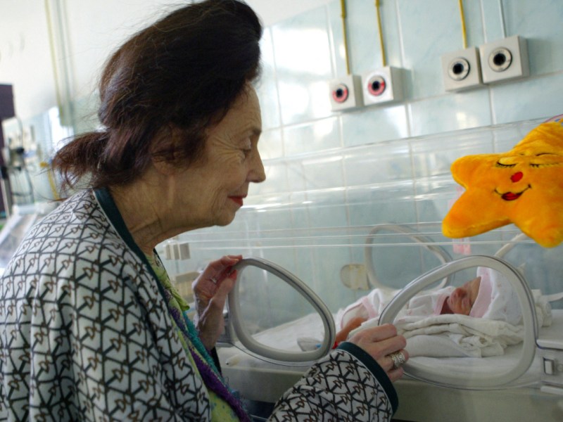 Eine Frau betrachtet ein Baby in einem Krankenhaus.