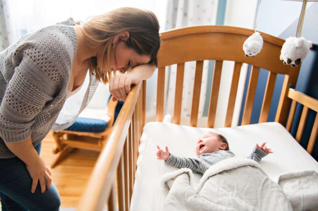 Eine müde, erschöpfte Mutter kümmert sich um ihr Baby.