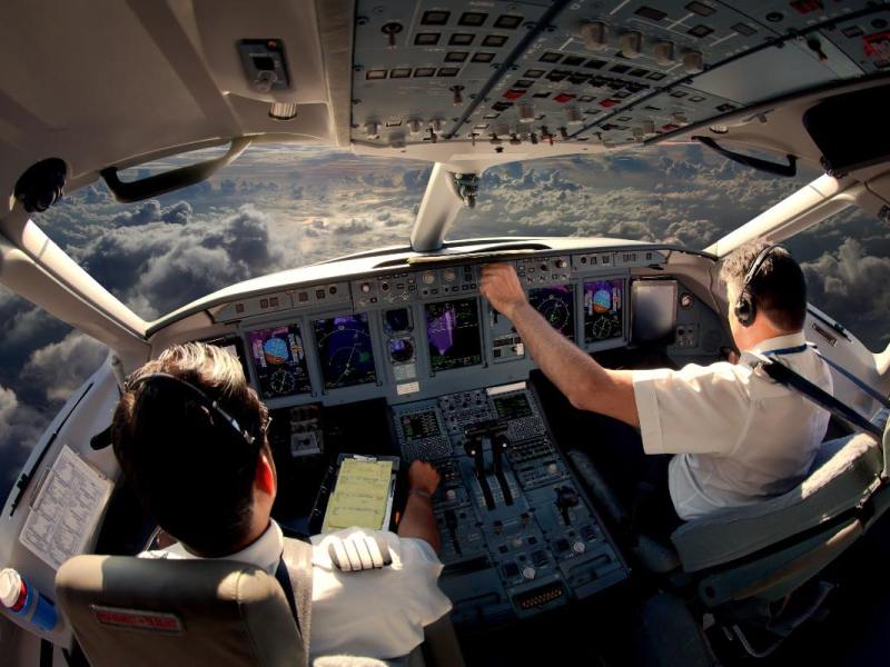 Zwei Piloten im Cockpit eines modernen Flugzeuges im Flug.