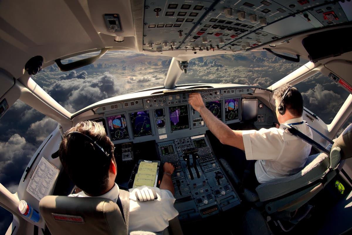 Zwei Piloten im Cockpit eines modernen Flugzeuges im Flug.