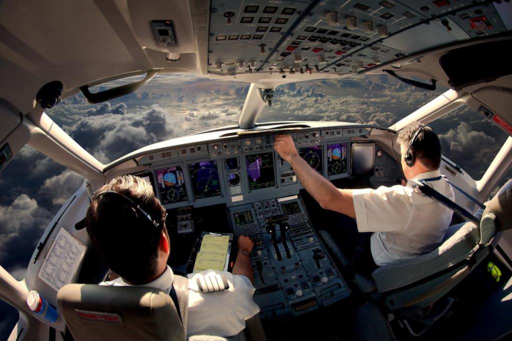 Zwei Piloten im Cockpit eines modernen Flugzeuges im Flug.